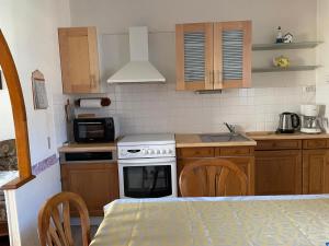 a kitchen with wooden cabinets and a stove top oven at Kerannie in Lanvollon