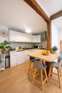 a kitchen with a wooden table and chairs at Maison de rue: Auch in Auch