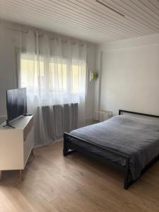 a bedroom with a bed and a flat screen tv at Bolbec Église in Bolbec