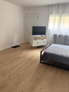 a bedroom with a bed and a dresser and a television at Bolbec Église in Bolbec