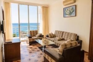 a living room with couches and a large window at Hotel Cameo in Kvariati