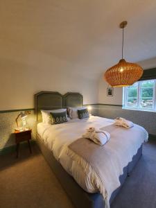 a bedroom with a large bed with two towels on it at Bel And The Dragon-Churt in Farnham