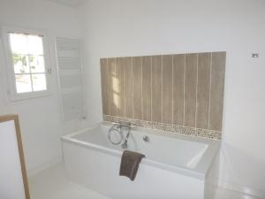 a white bath tub in a bathroom with a window at Villa Pigouille in Sainte-Marie-de-Ré +26 photos