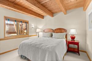 a bedroom with a bed and a red table with a lamp at 229 #35 by SkyRun Aspen in Snowmass Village