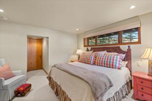 a bedroom with a bed and a chair and a window at 229 #35 by SkyRun Aspen in Snowmass Village