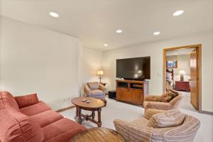 a living room with a couch and chairs and a flat screen tv at 229 #35 by SkyRun Aspen in Snowmass Village +28 photos