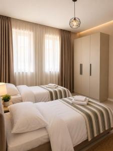 two beds in a hotel room with at L olive Villa in Zogaji