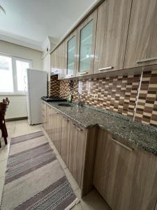 a kitchen with wooden cabinets and a white refrigerator at Lale Residence in Trabzon