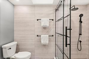 a bathroom with a shower with a toilet and towels at 229 #36 by SkyRun Aspen in Snowmass Village