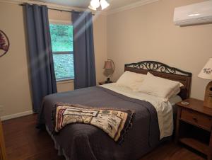 a bedroom with a bed and a window with blue curtains at Lazy Bull Cottages in Bull Shoals