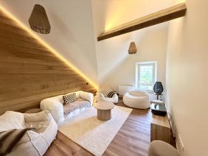 a living room with white furniture and wooden ceilings at L'escale de l'oisans in Livet-et-Gavet