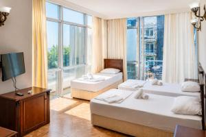 a hotel room with two beds and a large window at Hotel Cameo in Kvariati +66 photos