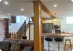 a kitchen with a counter and a bar with stools at Chapel House Accommodation in Culgaith +5 photos