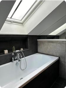 a bathroom with a bath tub with a skylight at Chapel House Accommodation in Culgaith