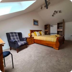 a bedroom with a bed and a chair at Chapel House Accommodation in Culgaith