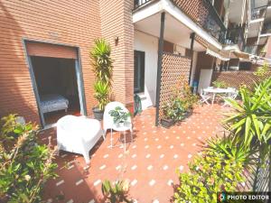 a patio with white chairs and plants on a building at Foce 24 - City Garden 2 - in Imperia