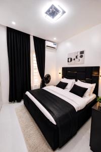 a black and white bedroom with a large bed at DipNik Residence in Lagos