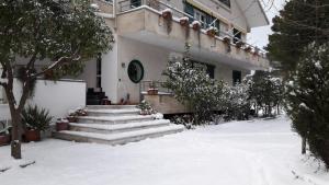 un edificio con escaleras en la nieve frente a él en B&B Sun Garden, en Montoro Inferiore