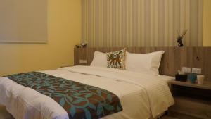 a bedroom with a large bed with a wooden headboard at Season Inn in Wujie