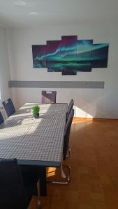 a table and chairs in a room with paintings on the wall at Rudiferienwohnung in Büdingen