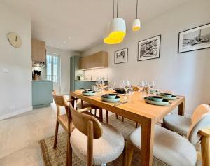 a dining room with a wooden table and chairs at GIte de la Grande Plage in Pléneuf-Val-André