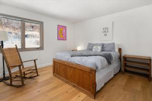 a bedroom with a bed and a chair and a desk at 29C by SkyRun Aspen in Snowmass Village +41 photos