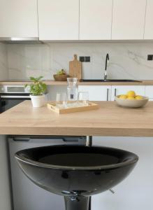 a kitchen counter with a bowl of fruit on it at Elounda Port Apartment in Elounda +11 photos