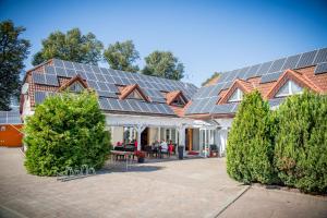 une maison avec des panneaux solaires sur le toit dans l'établissement Landhotel zum Baggernpuhl, à Wachow