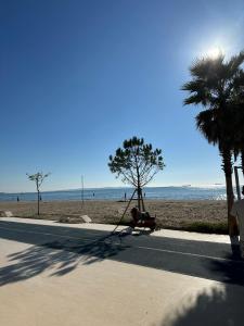 a person sitting on a bench next to the beach at Megan's Villa in Durrës