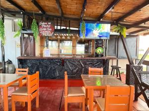 a restaurant with tables and chairs and a television at Hotel Las Terrazas de Bonanza in Zorritos
