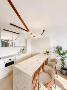a kitchen with a large marble counter and chairs at Eurovea Tower, 27th floor apartment, free parking in Bratislava