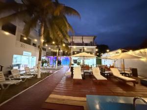 a deck with chairs and a swimming pool at night at Hotel Las Terrazas de Bonanza in Zorritos