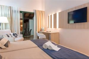 a hotel room with a bed and a flat screen tv at Botel Alcudiamar in Port d'Alcudia