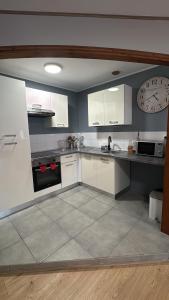 a kitchen with white cabinets and a clock on the wall at Superbe Duplex T2 62m2 - Rénové à Neuf ! in Croix +6 photos