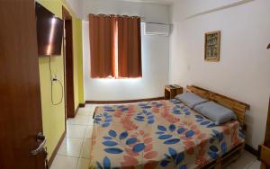 a bedroom with a bed with a colorful bedspread at RioVermelhopoint in Salvador