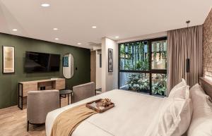 a bedroom with a large white bed and a window at Kukun Edition El Angel in Mexico City