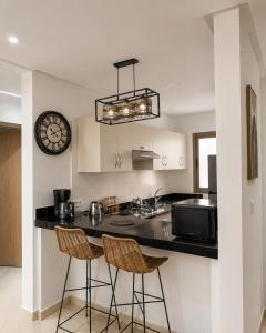 a kitchen with a counter and a clock on the wall at Asilah Ocean View Residence in Asilah