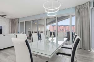 a dining room with a glass table and white chairs at TOPS'L Tides 0207 in Destin +43 photos