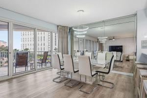 a dining room with a table and chairs and windows at TOPS'L Tides 0207 in Destin