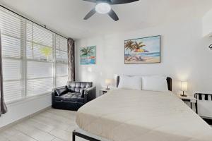 a bedroom with a bed and a black leather chair at Sunshine, Beach & Smiles on Ocean Drive in Miami Beach