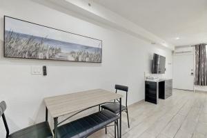 a dining room with a table and chairs and a television at Sunshine, Beach & Smiles on Ocean Drive in Miami Beach