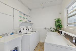 a kitchen with white counters and sinks and a window at Sunshine, Beach & Smiles on Ocean Drive in Miami Beach +18 photos