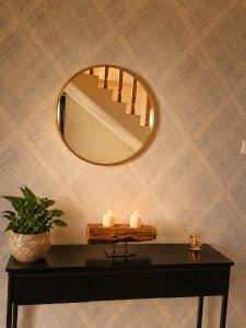 a table with two candles and a mirror at Noon Villa in Kanethi