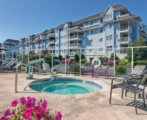 a apartment building with a pool and chairs and a playground at WorldMark Birch Bay in Birch Bay