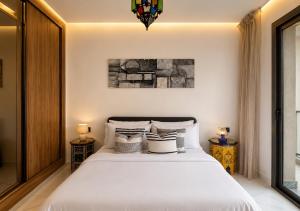 a bedroom with a large white bed with two lamps at Azra Mila Appart luxe famille uniquement in Saïdia
