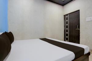 a white bed in a room with a door at Hotel O by OYO Shree Paying Guest House in Varanasi +21 photos