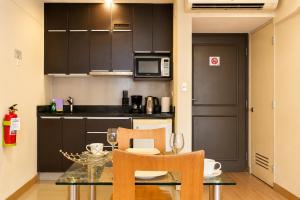 a kitchen with a table and chairs and a microwave at Diez Canseco by 2W Aparments Service in Lima