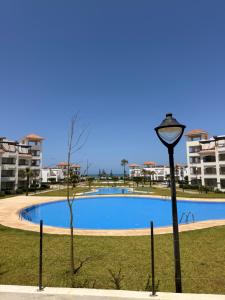 a street light in front of a swimming pool at Asilah Ocean View Residence in Asilah