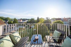 a patio with two chairs and a suitcase on a balcony at Sali Suite - Modern Attic Stay in Arbon