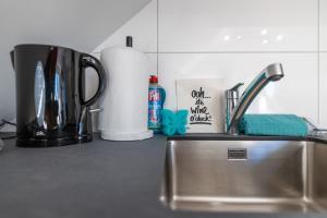 a kitchen counter with a sink and utensils at Sali Suite - Modern Attic Stay in Arbon +6 photos